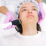 Woman receiving laser skincare treatment at a clinic.